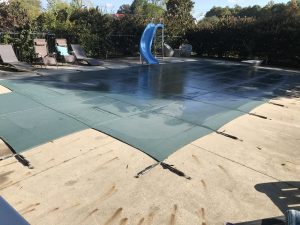 Picture of swimming pool with safety cover installed for winter.